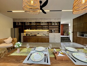 Una cocina moderna con estantes empotrados y un comedor listo para una comida.