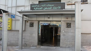 A building entrance with a digital sign displaying text in Arabic. - Al Ahfad Hotel Apartments  (Amman)