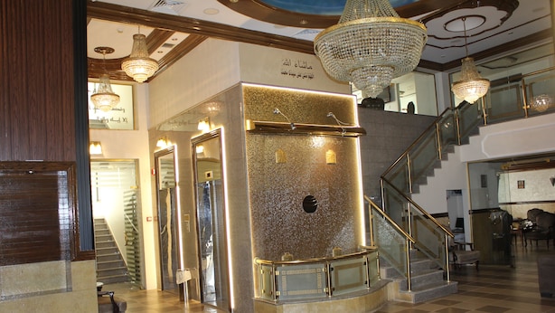 A lobby with a checkered floor, a staircase, and a chandelier. - Al Ahfad Hotel Apartments  (Amman)