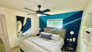 A bedroom with a bed, a ceiling fan, a nightstand with a lamp, and a wall-mounted TV. - MiamiVice Las Olas Near Beach & Park with Fire Pit! (Fort Lauderdale)
