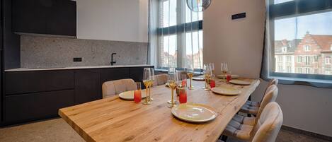 A modern kitchen with dark cabinets, a granite countertop, and a large window.