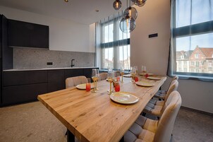 Una cocina moderna con armarios oscuros, encimera de granito y un ventanal grande.