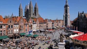A bustling square with historic buildings, a prominent church, and a tall clock tower.
