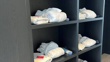 Un armari amb múltiples prestatges, cadascun amb tovalloles n'hi ha plegades i alguns productes de tocador.