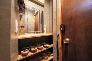 A bathroom with a wooden shelf holding shoes, a mirror, and toiletries. - Itabashi Ekimae Store Diamond Yuu (Tokyo)