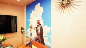 A room with a mural of an anime character, a sunburst clock, and a TV on the wall.