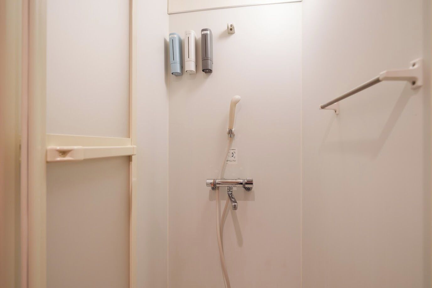 Une salle de bain équipée d’une douche, d’un porte-serviettes et d’un support à papier toilette.