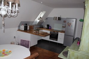 Kjøleskap, mikrobølgeovn og høy barnestol