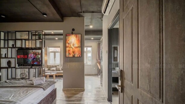Un salon moderne doté d’un grand lit, d’une cheminée et d’un téléviseur fixé au mur, sur lequel on peut regarder Netflix.