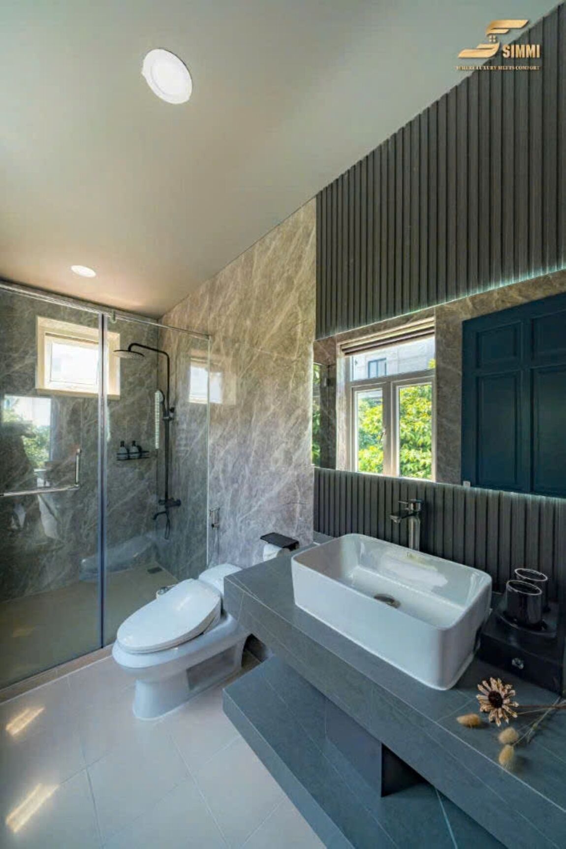 A modern bathroom with a glass-enclosed shower, a freestanding bathtub, and a large mirror.