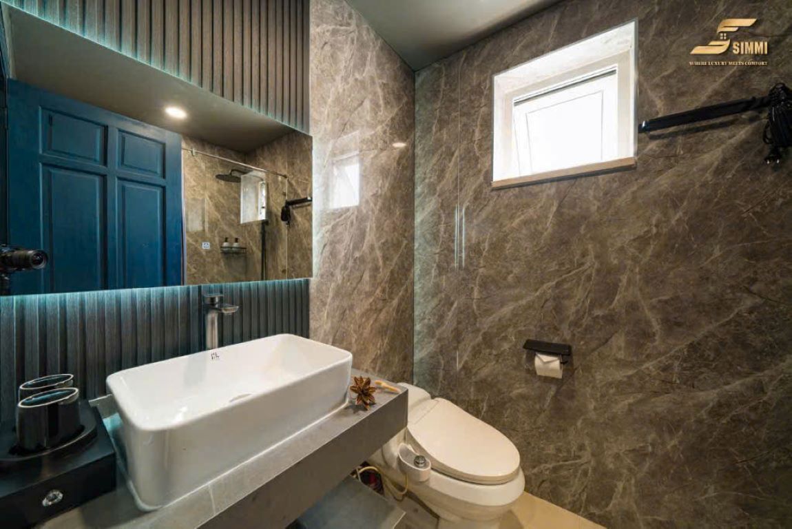 Un baño moderno con una bañera grande, un inodoro y un espejo.