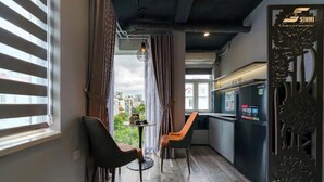 Une cuisine moderne dotée d’un réfrigérateur encastré et d’un petit coin repas avec deux chaises et une table.