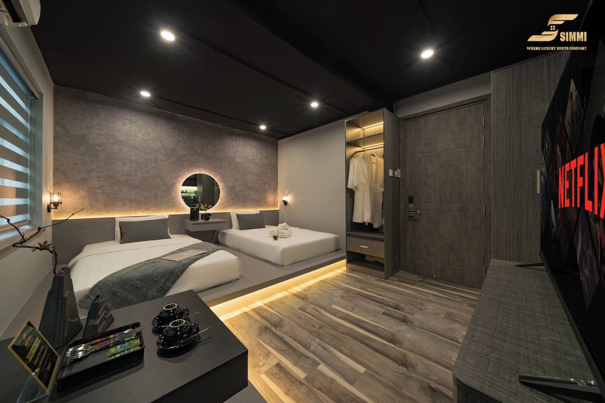 Een moderne slaapkamer met een groot bed, nachtkastjes, een inloopkast en een televisie.