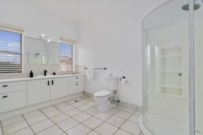A modern bathroom with a toilet, sink, and shower. - The Seabreeze Sanctuary (WOORIM)