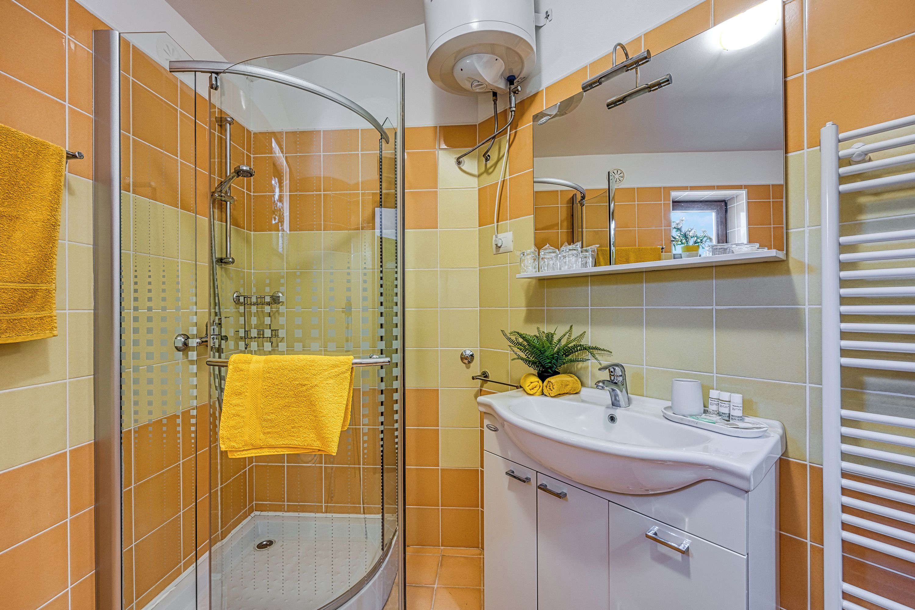 A bathroom with a glass shower enclosure, a white sink, and a mirror above it.