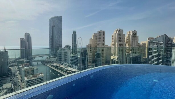 A cityscape with high-rise buildings and a large swimming pool.