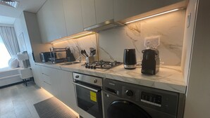 A modern kitchen with a built-in dishwasher, oven, microwave, and a coffee maker on the countertop.