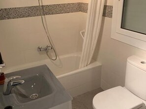 Une salle de bain avec une baignoire, un lavabo et des toilettes.