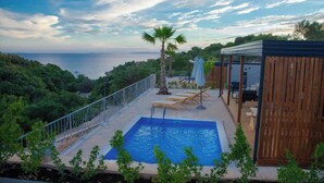 A rooftop pool with a view of the sea, surrounded by greenery and wooden structures. - Lastura Mobile Homes (Novalja)