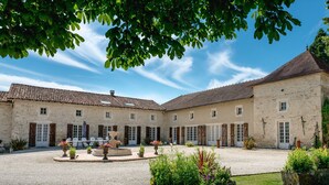 A courtyard with stone buildings, a central fountain, and surrounding greenery. - La Rosairie - max. 2 people (Bouin)