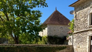 A swimming pool with clear blue water, a pink flamingo float, and stone buildings in the background. - La Rosairie - max. 2 people (Bouin)
