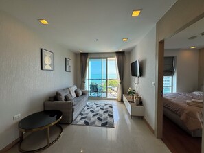Deluxe Condo, Partial Sea View | Living area | Flat-screen TV - The Palm Wongamat Beach Pattaya by PSR (Pattaya)