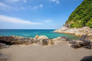 Playa en los alrededores, playa de arena blanca y camastros 