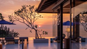 A modern outdoor seating area with a view of the sunset over the ocean. - Villa La Thalé (Kamala)