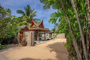 A tropical resort with a traditional wooden structure, stone walls, and lush greenery. - Villa La Thalé (Kamala)