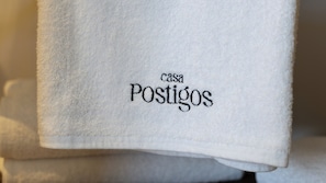 Un asciugamano bianco con ricamato il testo 'Casa Postigos'.