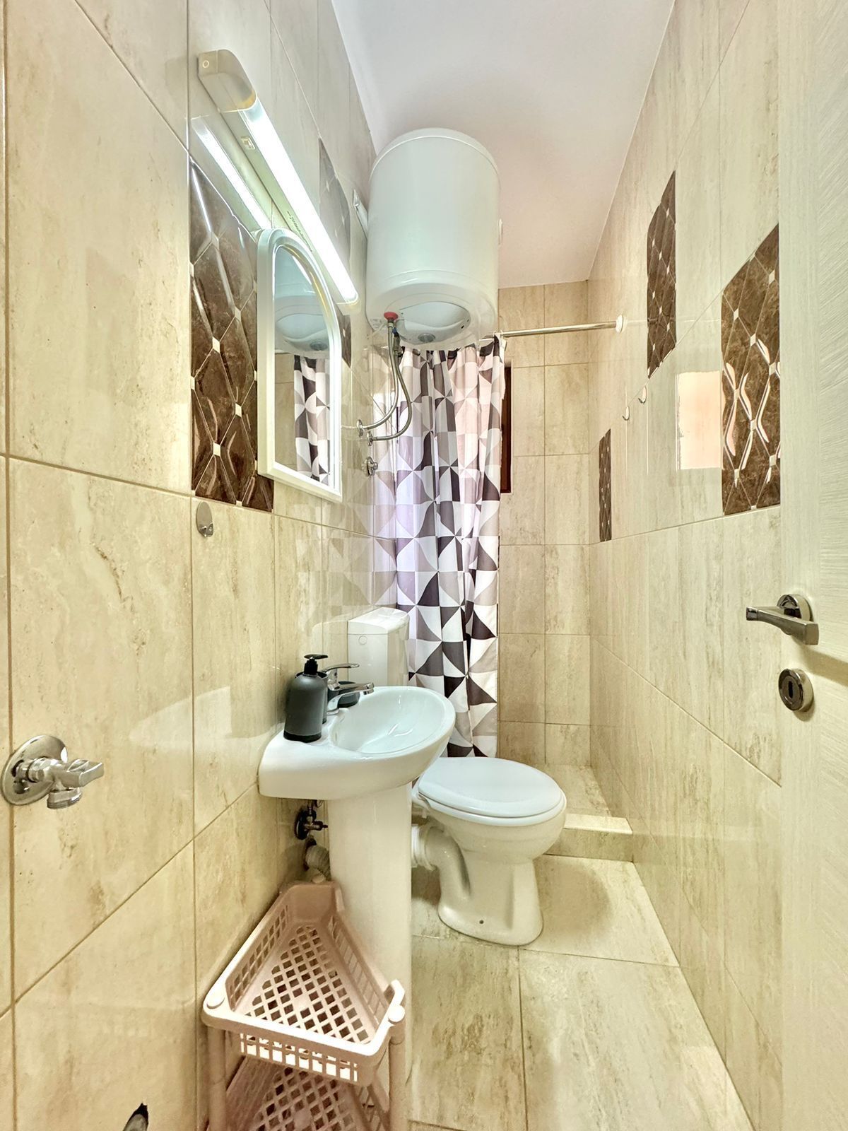 A bathroom with a white sink, toilet, and shower curtain.