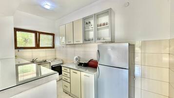 Comfort Apartment, Garden View | Private kitchen | Mini-fridge, stovetop, cookware/dishes/utensils, dining tables