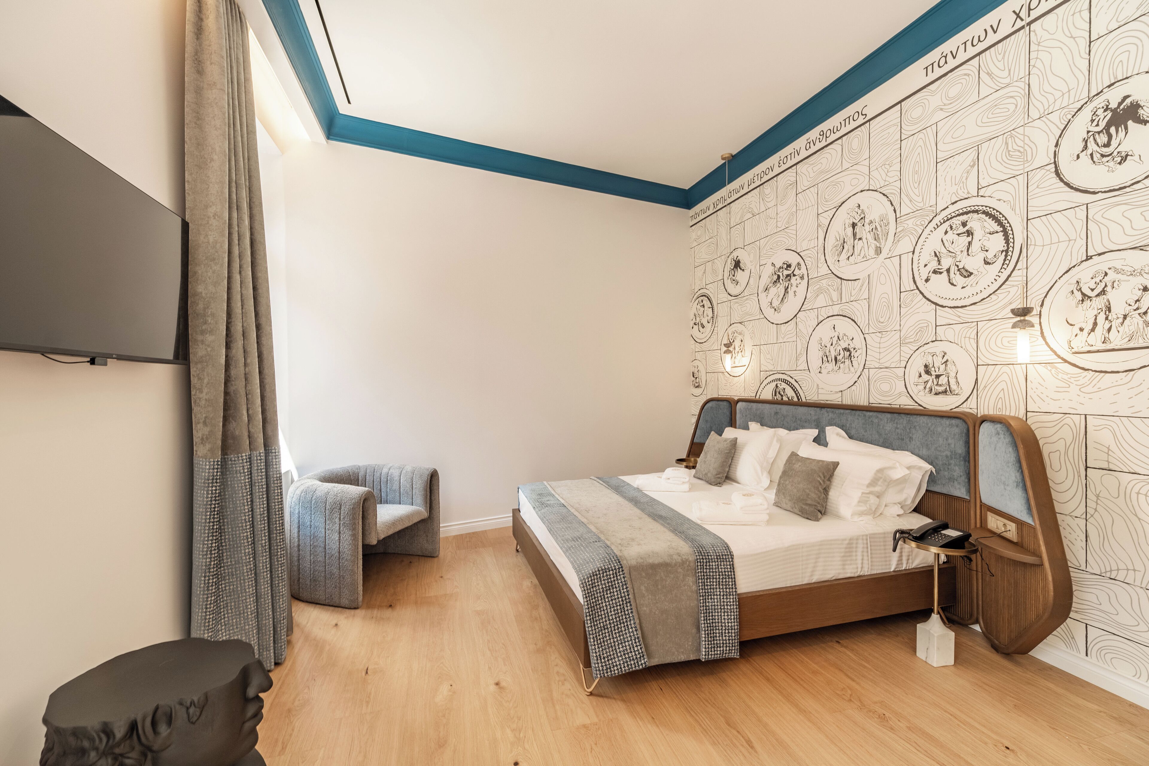 A bedroom with a bed, bedside table, and a wall with a patterned design.
