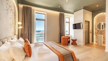 Suite junior, balcón, vista al mar | Ropa de cama de alta calidad y minibar