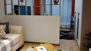 A modern living room with a sofa, a coffee table, and a decorative partition with shelves.