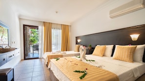 Une chambre d’hôtel avec deux lits, un balcon et une vue sur la verdure.