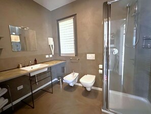 Een moderne badkamer met een douche, toilet en hygiëneschuimer.