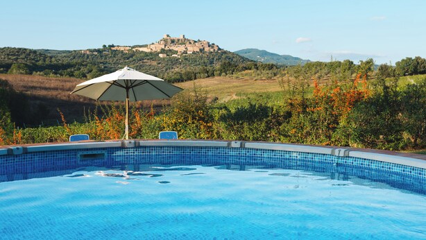 A swimming pool with a view of a hilltop castle. - Agriturismo Podere Ristella - Wine&Food (Roccastrada)