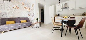 Relax in this stylish living space with a sofa, dining area, and kitchen.