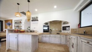 A spacious kitchen with a large island, modern appliances, and a decorative sign that reads "BAR". - Luxurious Villa with Heated Pool and Jacuzzi in Scenic Nans-les-Pins (Saint-Rémy-de-Provence)