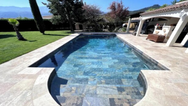 A rectangular swimming pool with stone tiles, surrounded by a patio area with a pergola and seating. - Luxurious Villa with Heated Pool and Jacuzzi in Scenic Nans-les-Pins (Saint-Rémy-de-Provence)