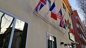 A building with multiple flags, including the British, American, and Italian flags, and a sign indicating it is a hotel. - Hotel Tito (Mestre)