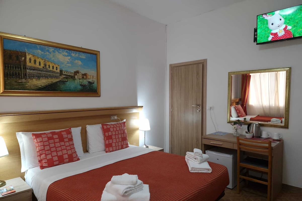 Habitación cuádruple Confort, varias camas | Edredón, decoración personalizada, muebles diferentes y escritorio