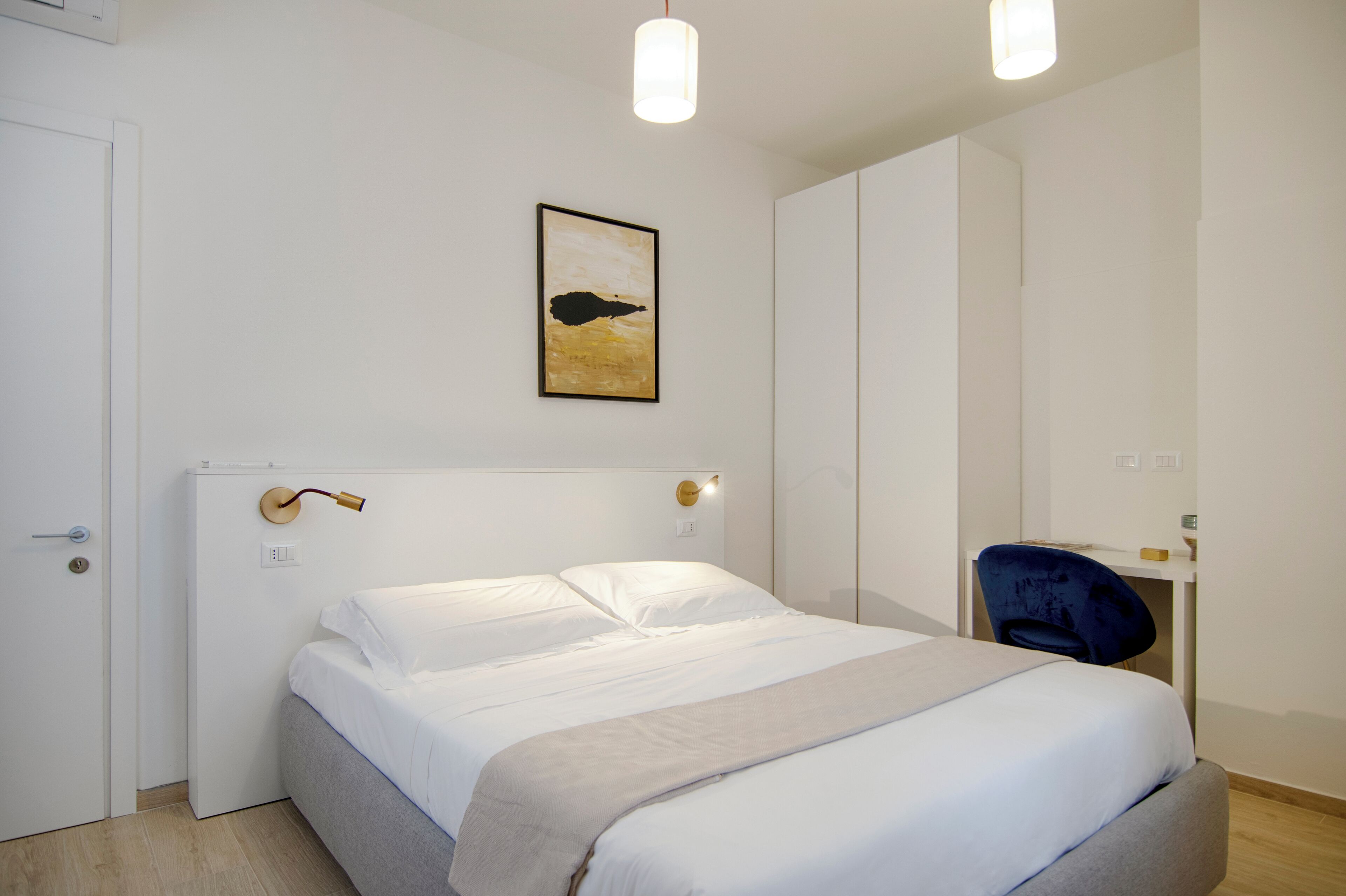 Een moderne slaapkamer met een bed, een bureau en een stoel.