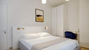 Een moderne slaapkamer met een bed, een bureau en een stoel.