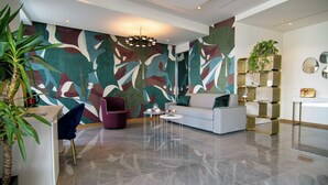 Uma sala de estar moderna com um grande mural abstrato, um sofá, uma mesa de centro e uma planta.