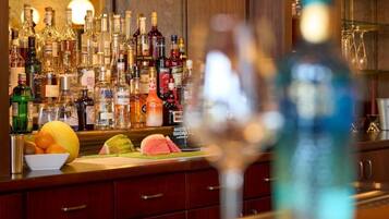 A bar area with various liquor bottles and a fruit bowl.