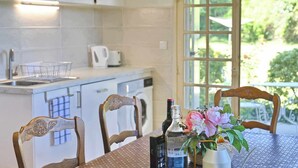 A kitchen with white cabinets, a sink, and a window with a view of greenery.
