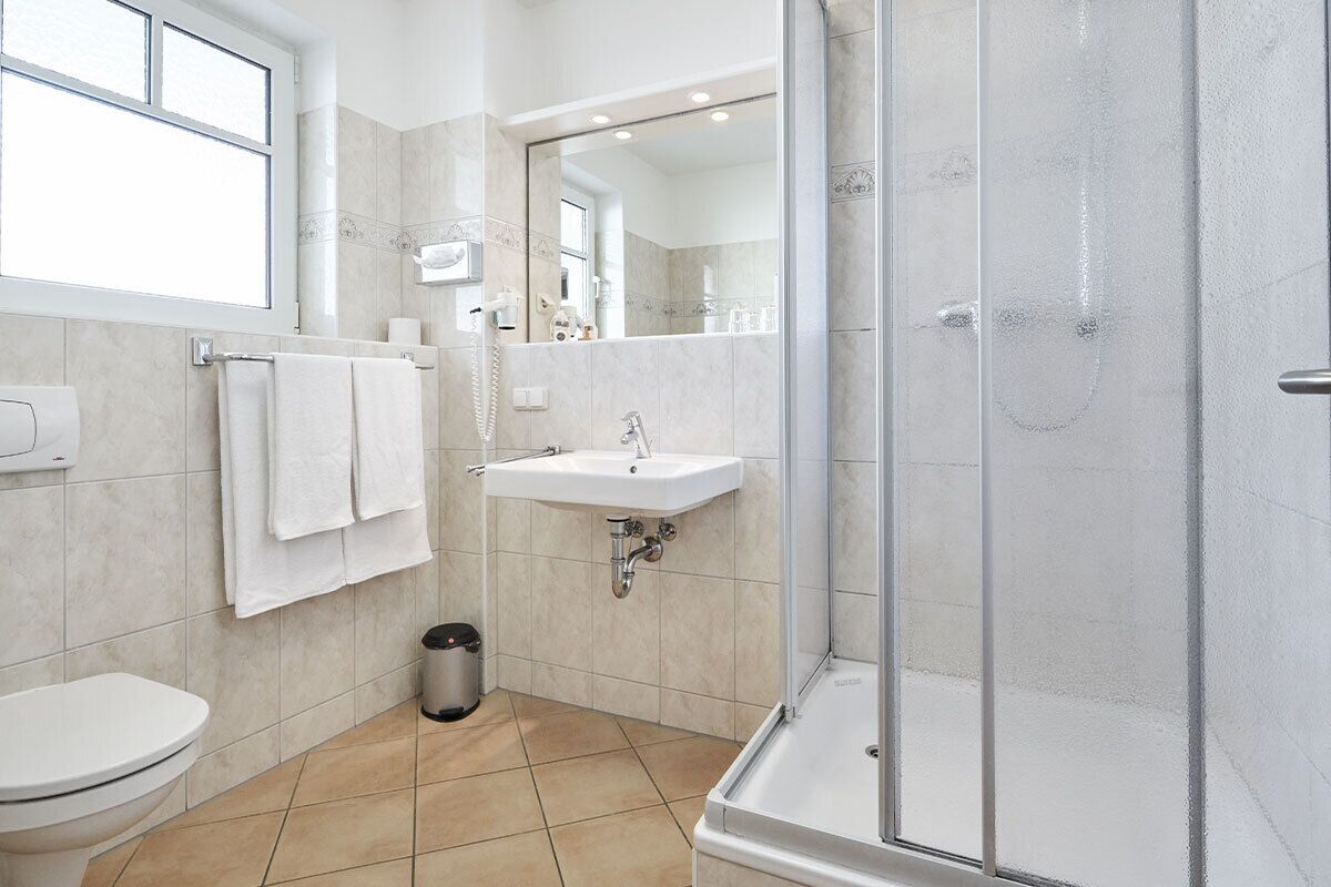 Un baño moderno con inodoro, lavabo y ducha.