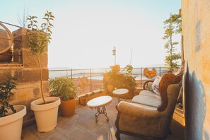 A rooftop terrace with potted plants, a table, and a sofa. - Kilim (Nevsehir)
